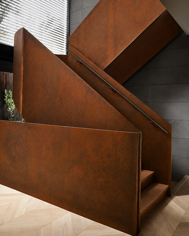 Escalier sur mesure en acier Corten avec patine brune naturelle et habillage métallique architectural