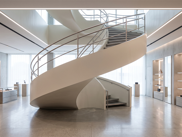 Escalier architectural hélicoïdal blanc à géométrie sculpturale dans un espace intérieur contemporain