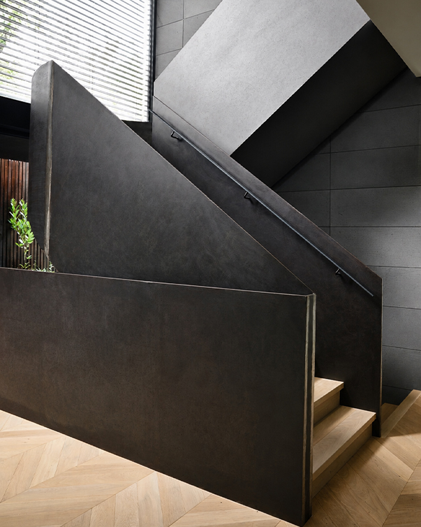 Escalier sur mesure avec structure métallique sombre et marches en bois dans un intérieur contemporain