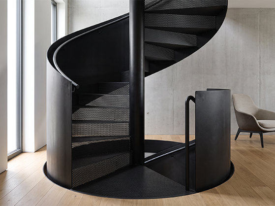 Escalier colimaçon métallique noir sur mesure avec noyau central dans un intérieur contemporain