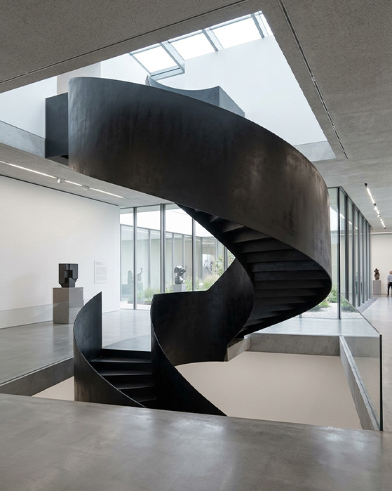 Escalier hélicoïdal intérieur sur mesure en acier noir avec structure courbe sculpturale