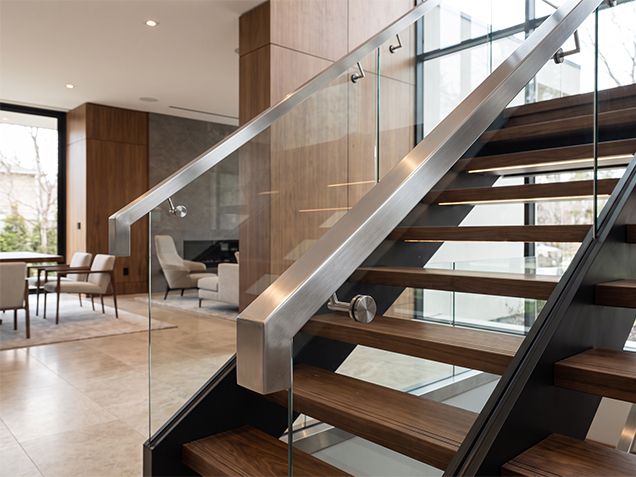 Escalier sur mesure avec marches en bois, garde-corps en verre et main courante en inox brossé