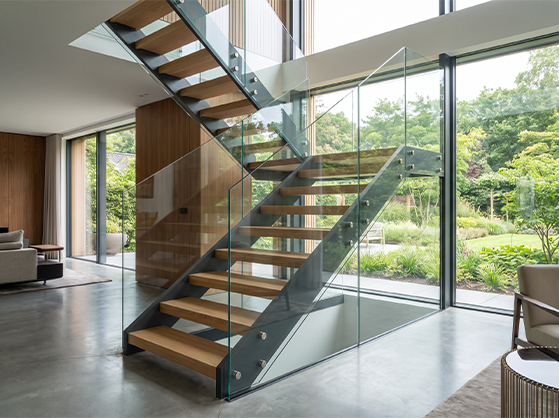 Escalier sur mesure pour villa avec structure métallique, marches en bois et garde-corps en verre