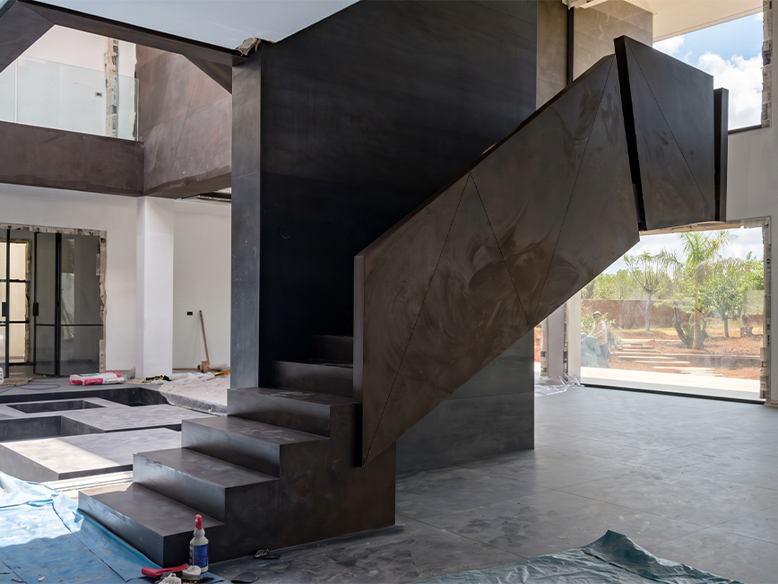 Installation d’un escalier métallique sur mesure en acier dans une villa contemporaine en chantier