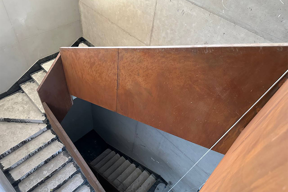 Détail de la structure métallique d’un escalier sur mesure avec panneaux en acier et raccords en cours de finition